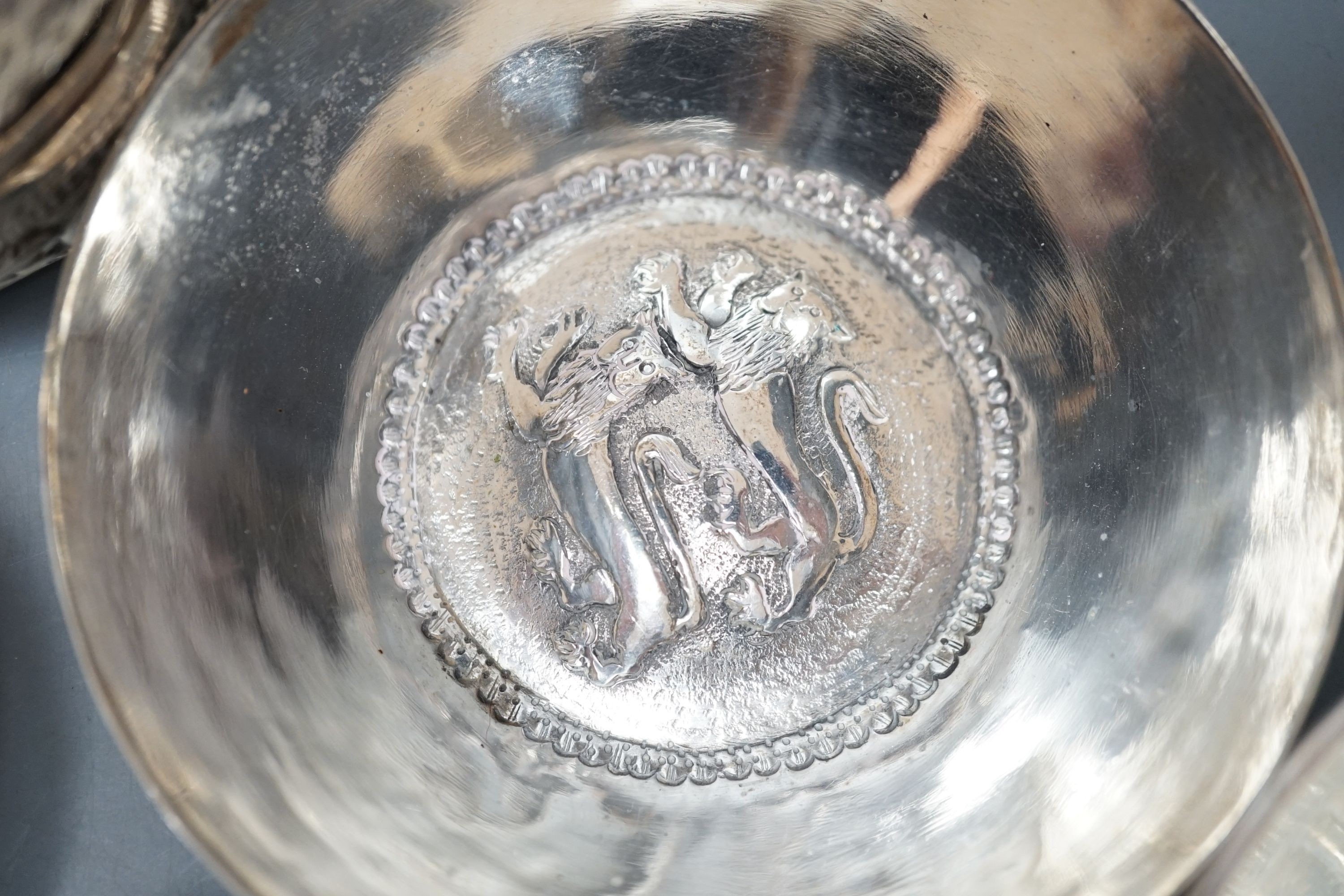 Four small Rangoon white metal bowls together with a simile basket and six small white metal bowls with heraldic motifs, gross 24.5oz.